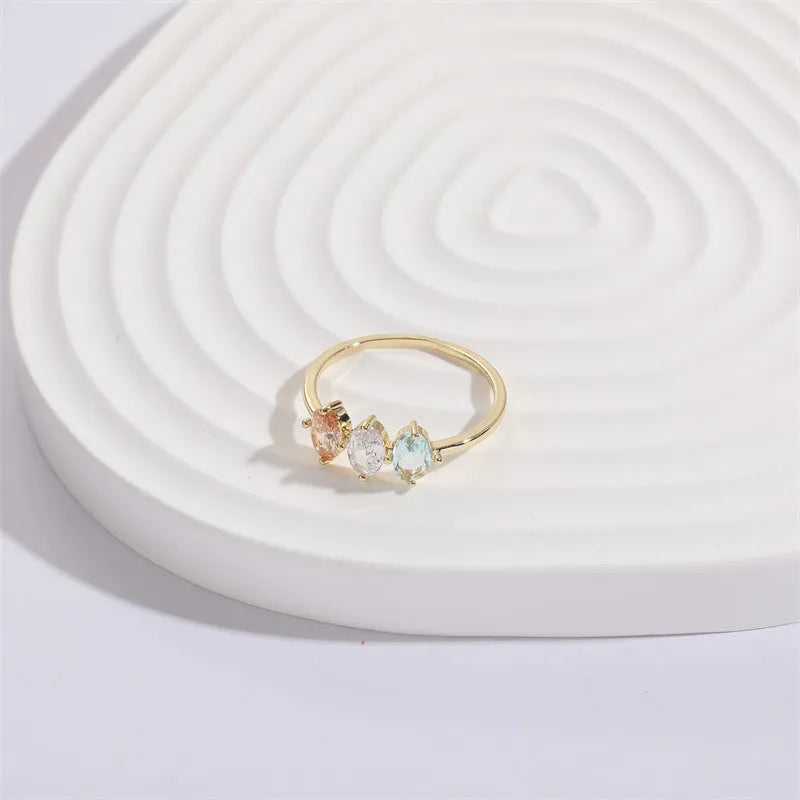 Geometric horse eye ring with tricolour zircon stones on a 14k gold-plated copper band.