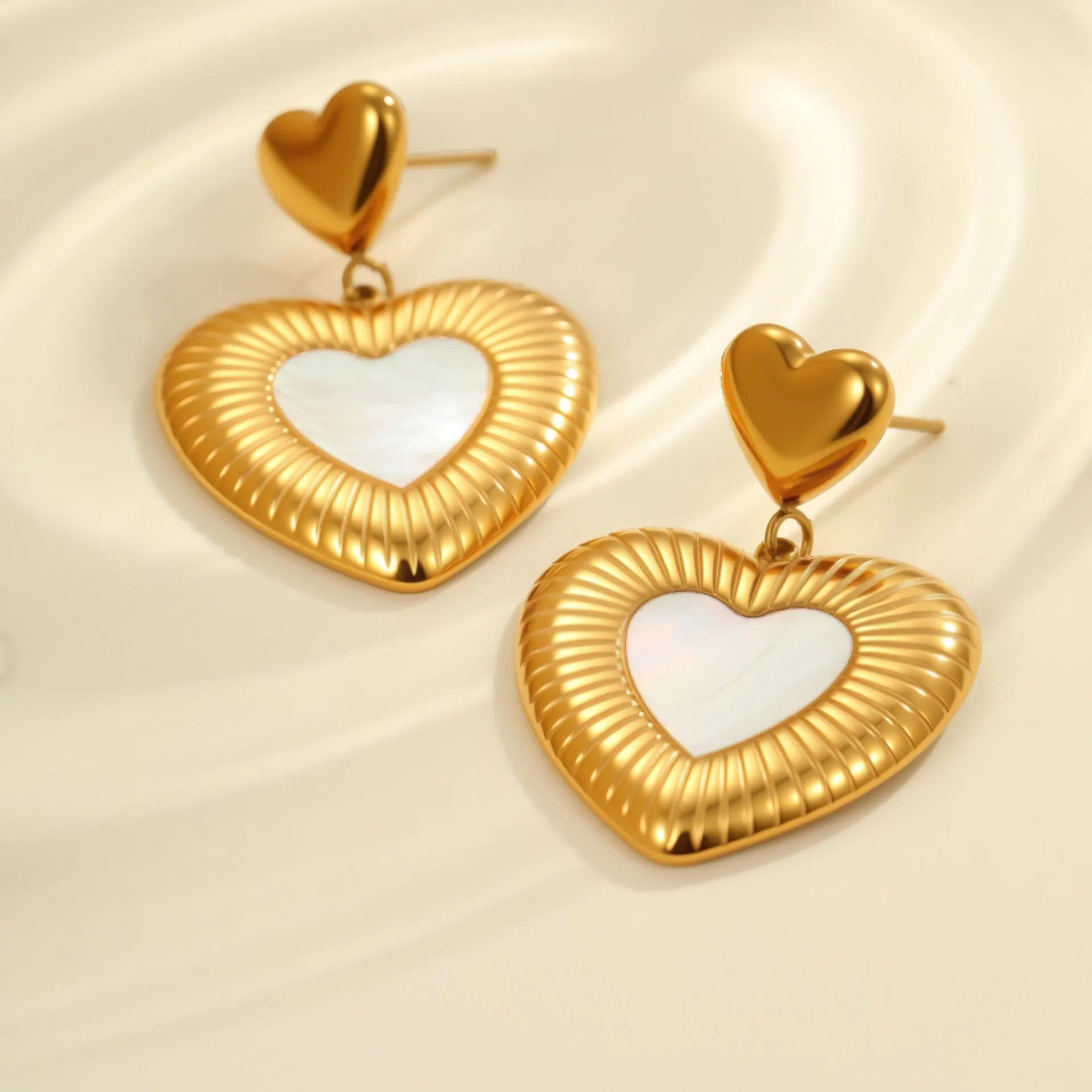 A pair of gold heart-shaped white fritillary earrings for women, made from stainless steel with 18K electroplating.