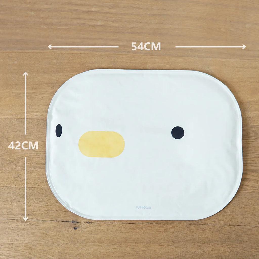 Blue chick-shaped washable pet cooling mat on a wooden floor.