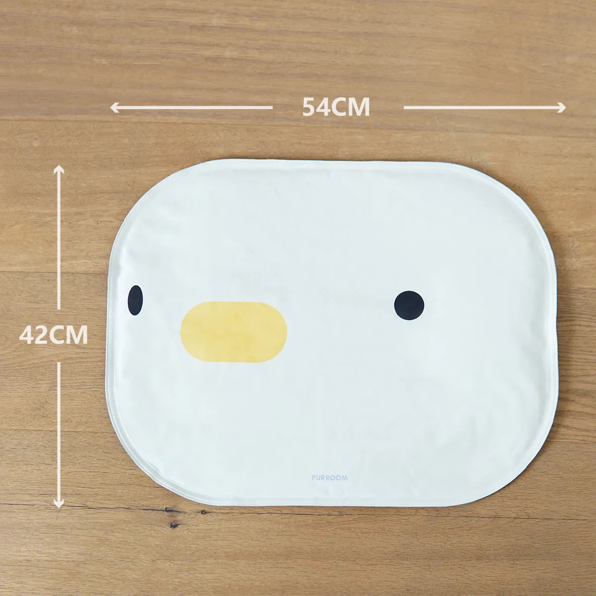 Blue chick-shaped washable pet cooling mat on a wooden floor.
