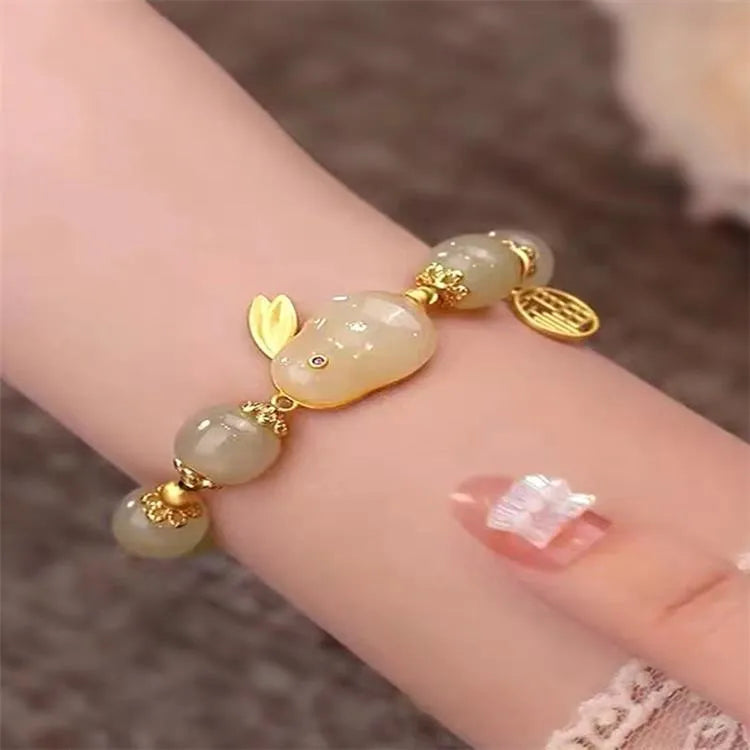 Green jade hare bracelet with black cord showing fu character charm and lily detailing