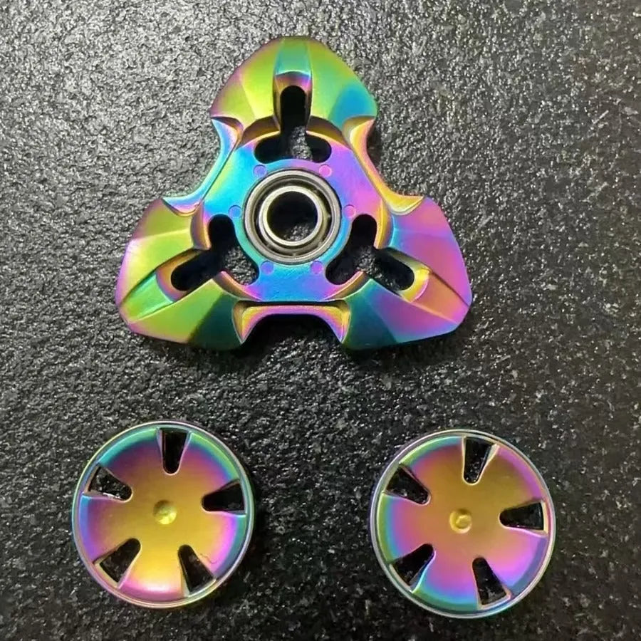 Alloy metal decompression rotating fingertip gyro toy in gun colour and colourful options on a solid background.