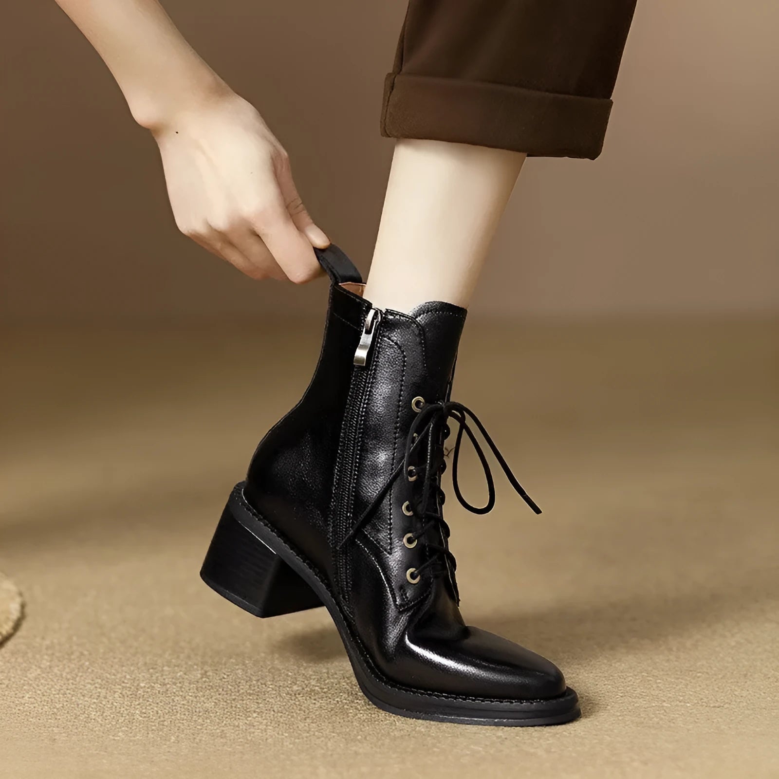 Women's black pointed-toe ankle boots with a short shaft and a low heel on a plain background.