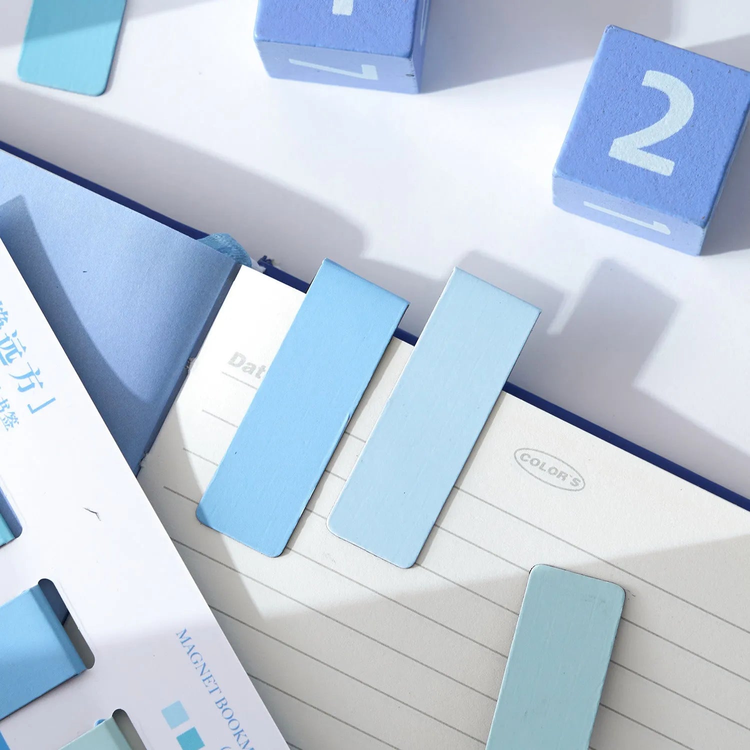 Set of four miniature magnetic bookmarks in soft pastel colours with rectangular design and embedded magnets