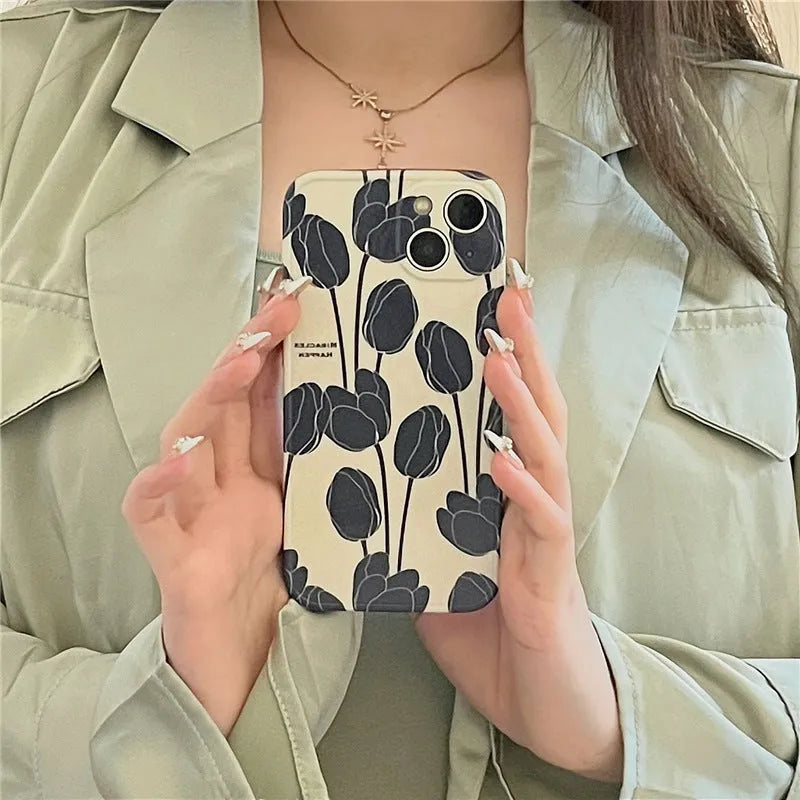 Black silicone iPhone case with a detailed tulip floral pattern on the back.