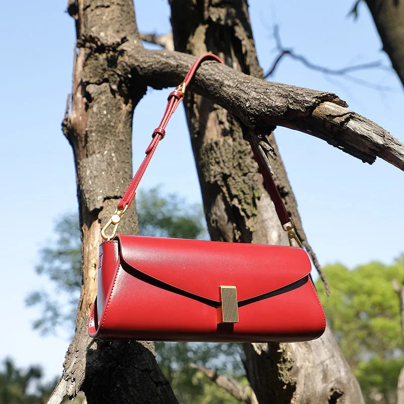 Milky white cowhide leather women's crossbody bag showing clamshell opening and pillow shape.