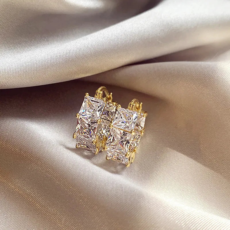 Geometric U-shaped zircon ear rings with electroplated gold finish on copper construction