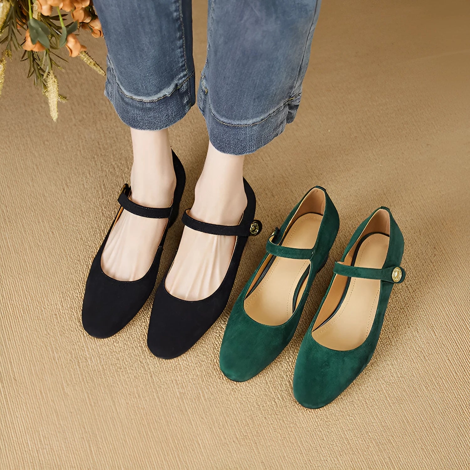 Black suede women's Mary Jane shoes with a chunky heel and square toe on a plain background.
