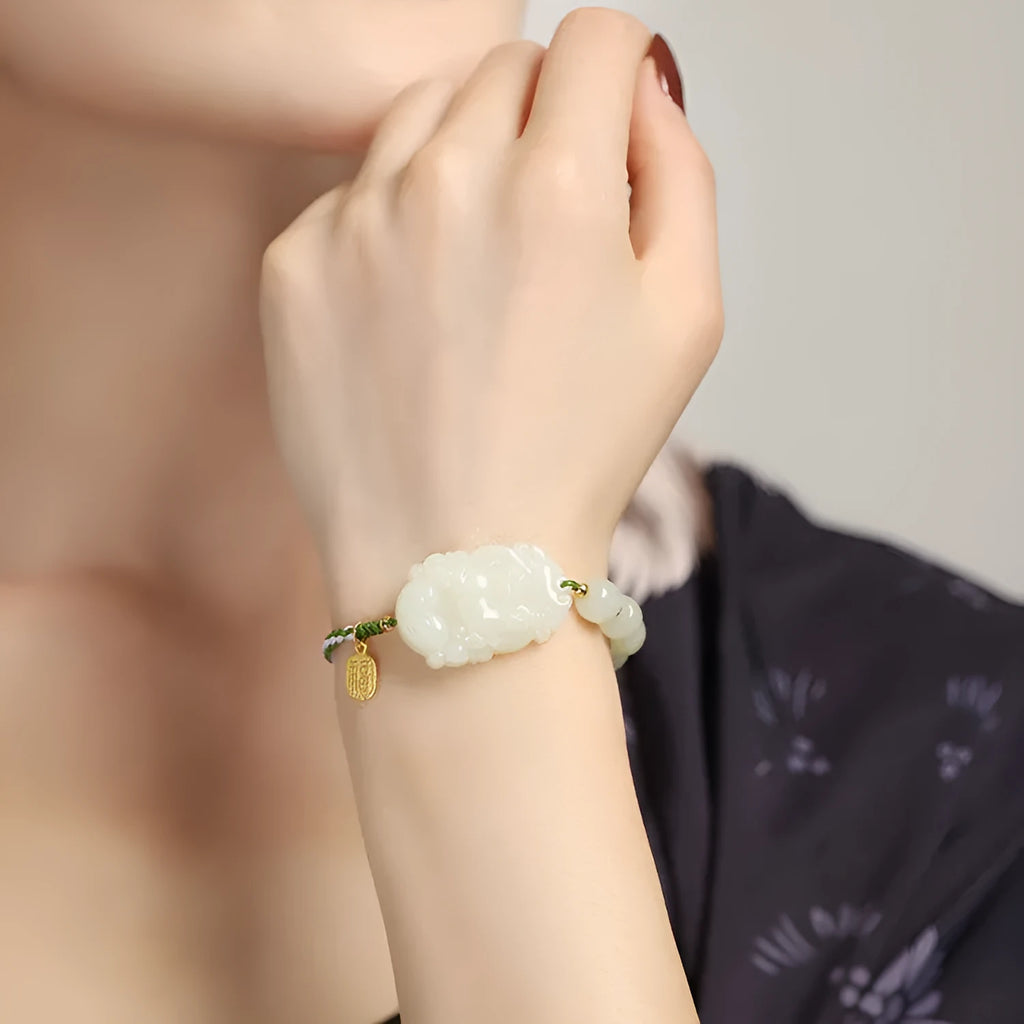 Modern red rope bracelet with a Hetian jade rabbit zodiac charm and a small silver card.