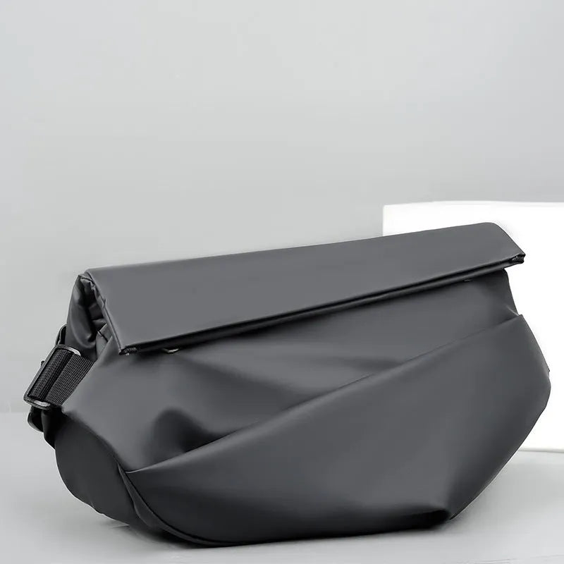 Men's grey crossbody bag with motorcycle sling strap, horizontal square shape, and zipper opening