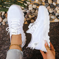 Women's low-top mesh sneakers in grey with a flyknit pattern and platform sole.