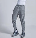 Loose fit grey sports cropped pants with a printed elastic waistband, shown on a model.