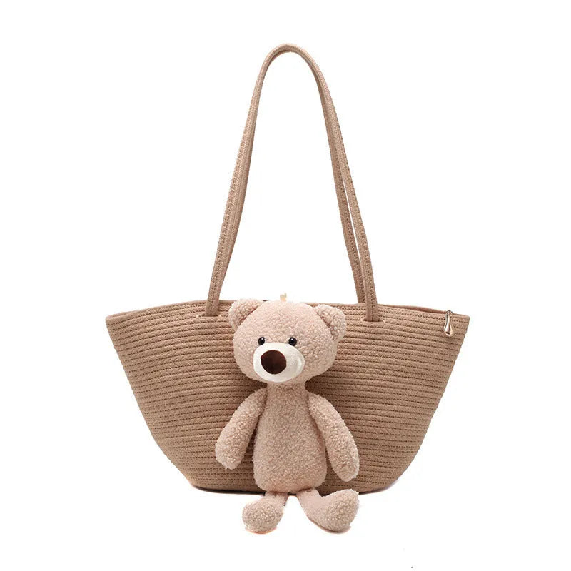 A woven dumpling-shaped shoulder bag in cotton and linen fabric with a three-dimensional front pocket.
