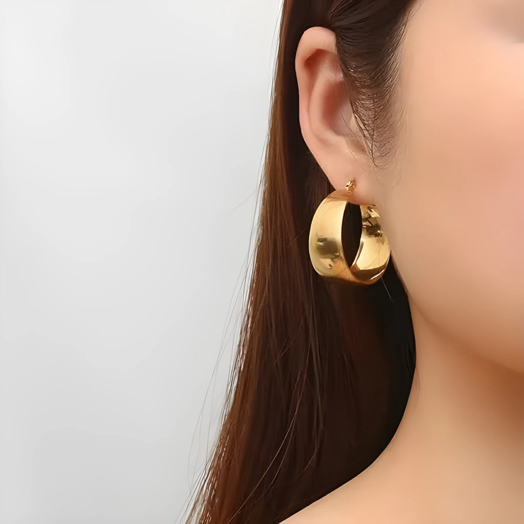 Widened curved stainless steel earrings in gold or steel colour, available in 25mm or 30mm sizes