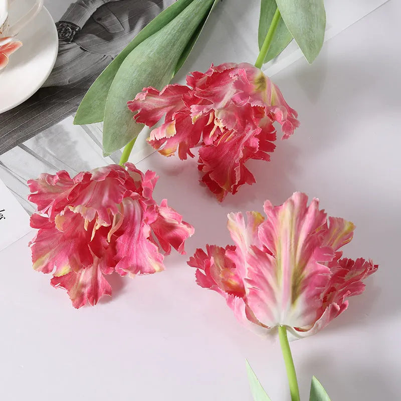Artificial toothed tulip fake flower arrangement in bright red colour on wooden table