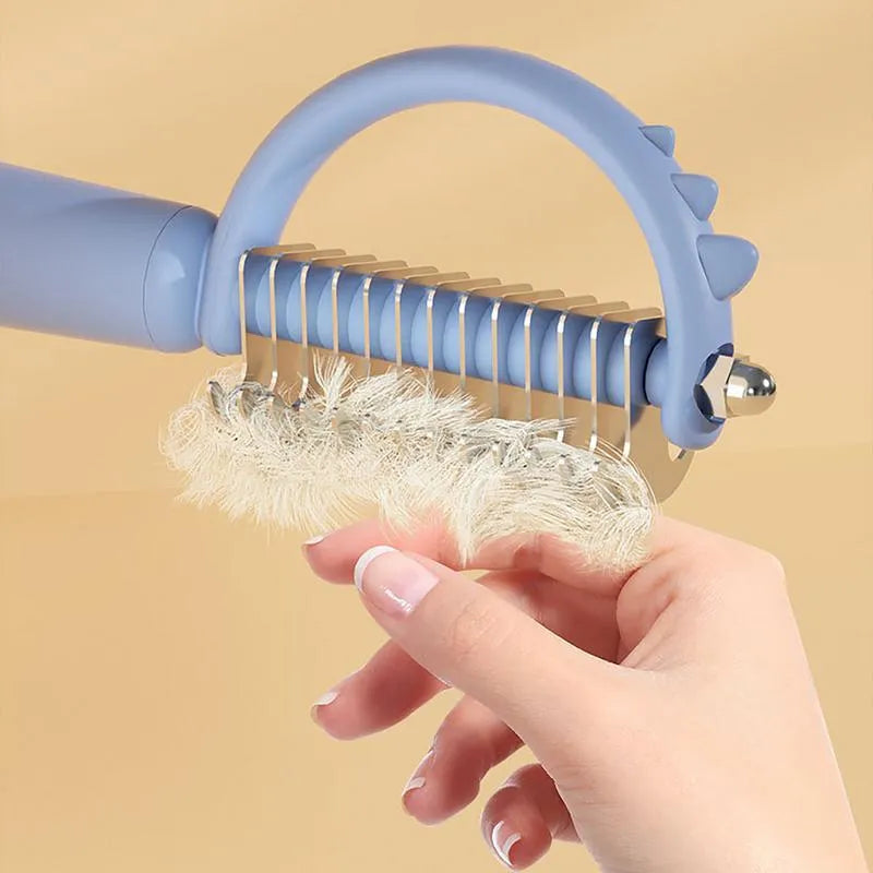 Blue dinosaur-shaped cat brush with stainless steel bristles for grooming and self-cleaning function