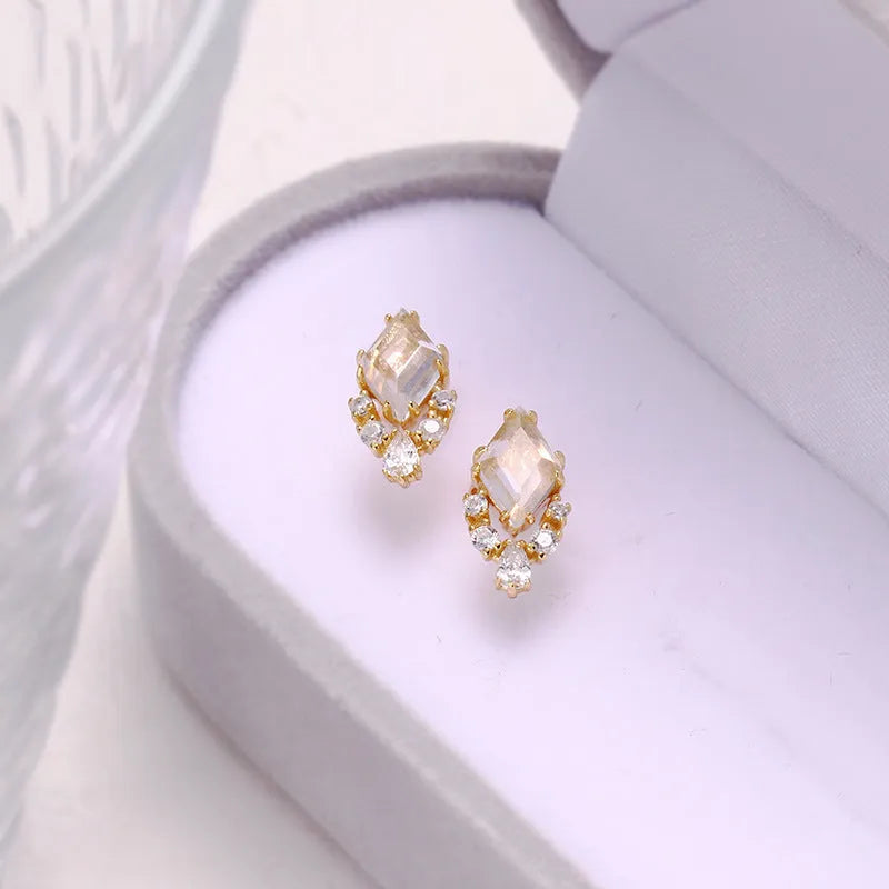 Geometric silver earrings with sweet white crystal studs showing structured design