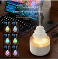 White cloud-shaped humidifier diffuser with multi-colour LED lights on a wooden surface.