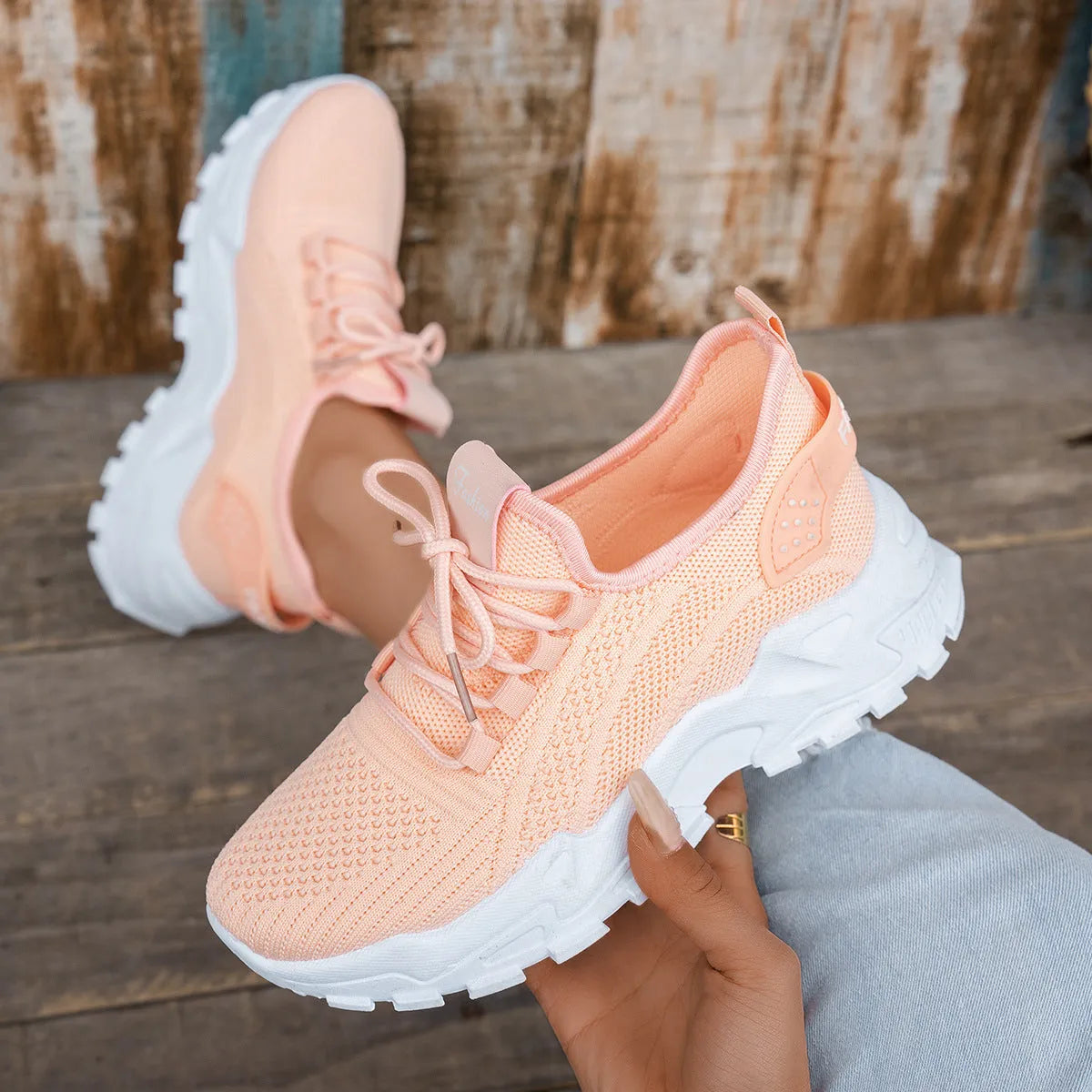 Women's white Flyknit mesh casual sports shoes with flat heel and lace-up front.