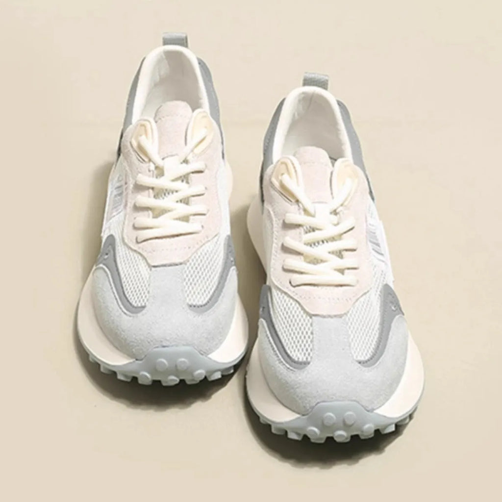 Women's grey and pink low-top retro sneaker with round toe and flat rubber sole.