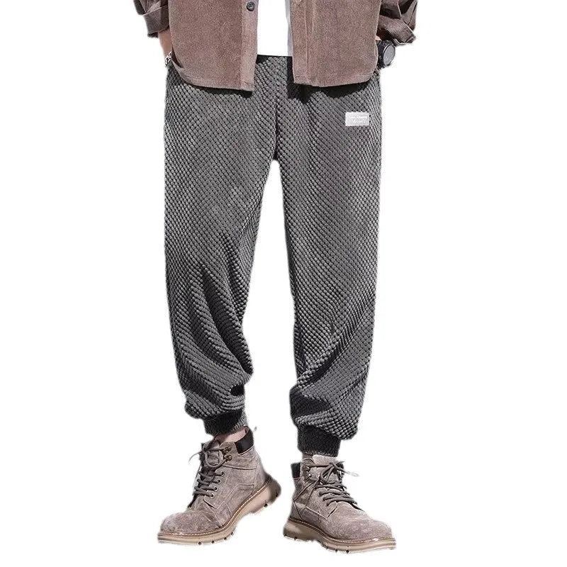Man wearing grey ankle-tie sweatpants, showing the straight leg and adjustable cuff detail.