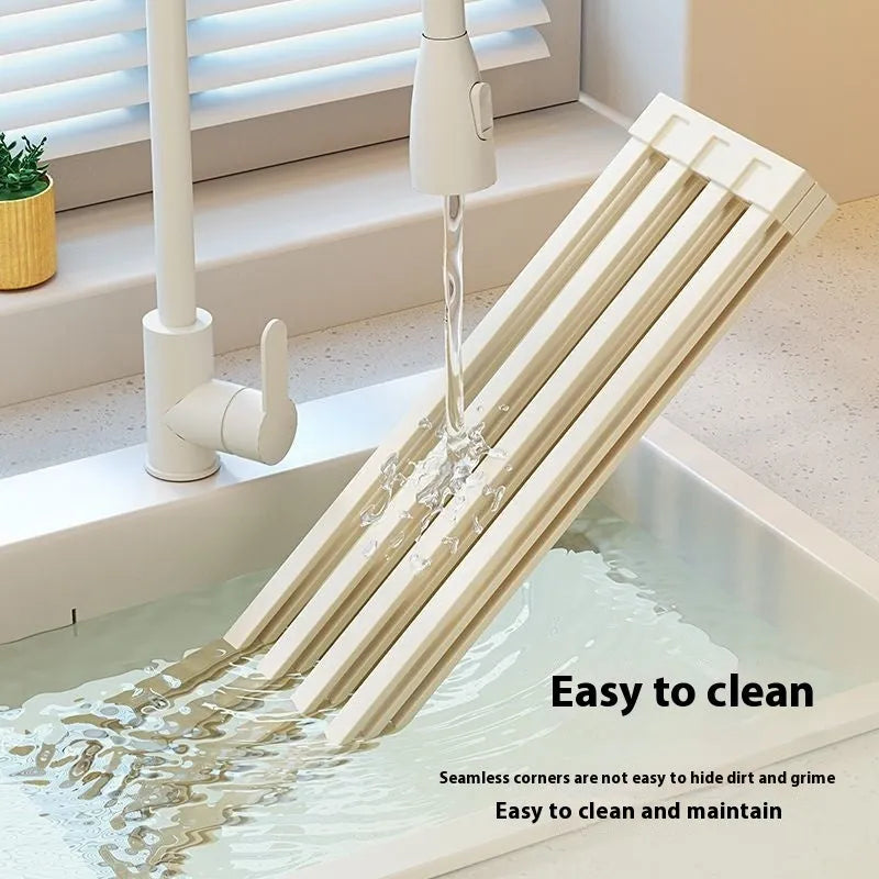 Milky white foldable stainless steel kitchen draining rack with tri-fold design on a sink