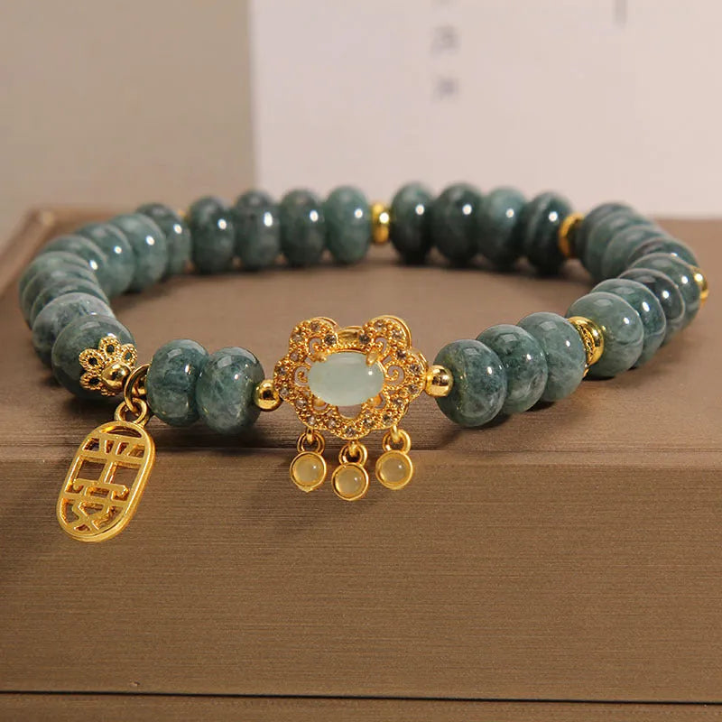 Close-up of a women's bracelet with natural emerald green jade abacus beads and a metallic alloy safety lock clasp.