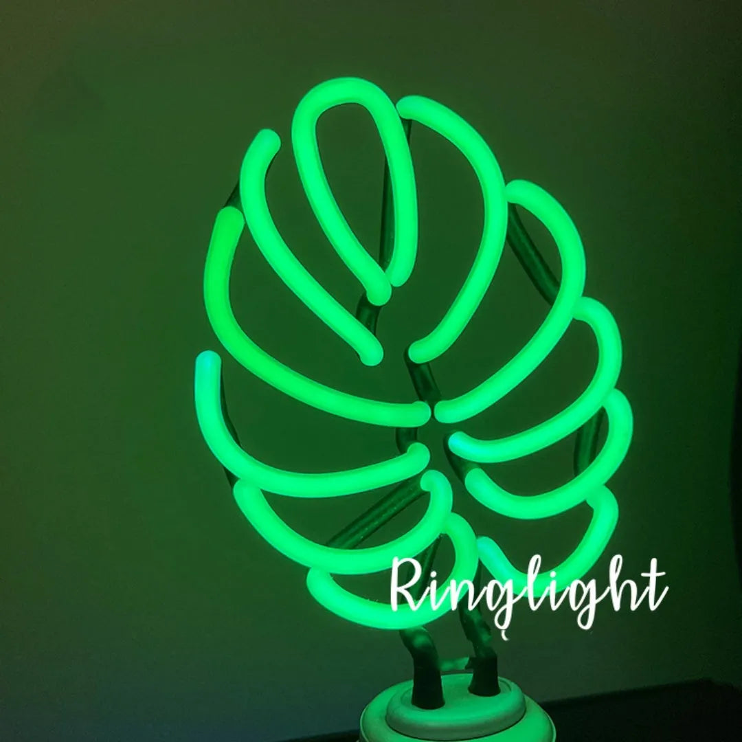 White bamboo-shaped desktop lamp with green light, USB cable, and minimalist design on wooden desk