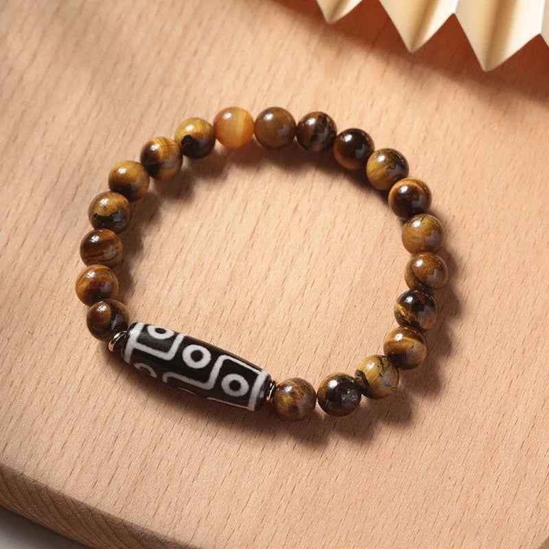 Close-up of a single circle tigereye stone Buddha rosary bracelet showing the chatoyant beads on a string.