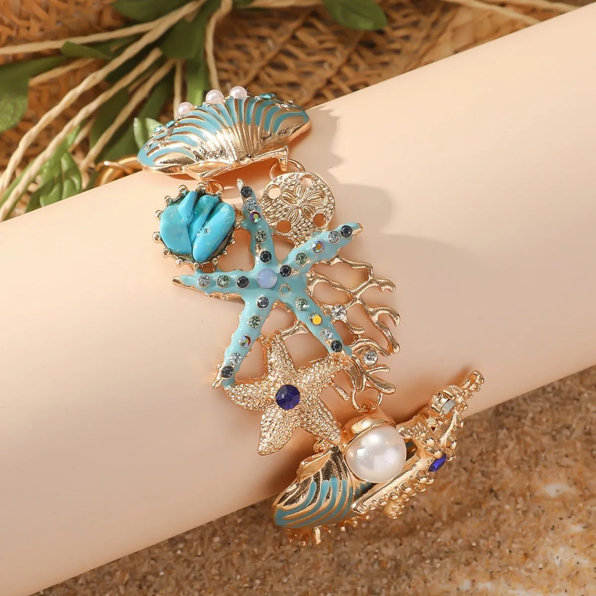 Women's alloy bracelet with starfish design in turquoise, coral red, or coral blue with marine shell and boat anchor elements