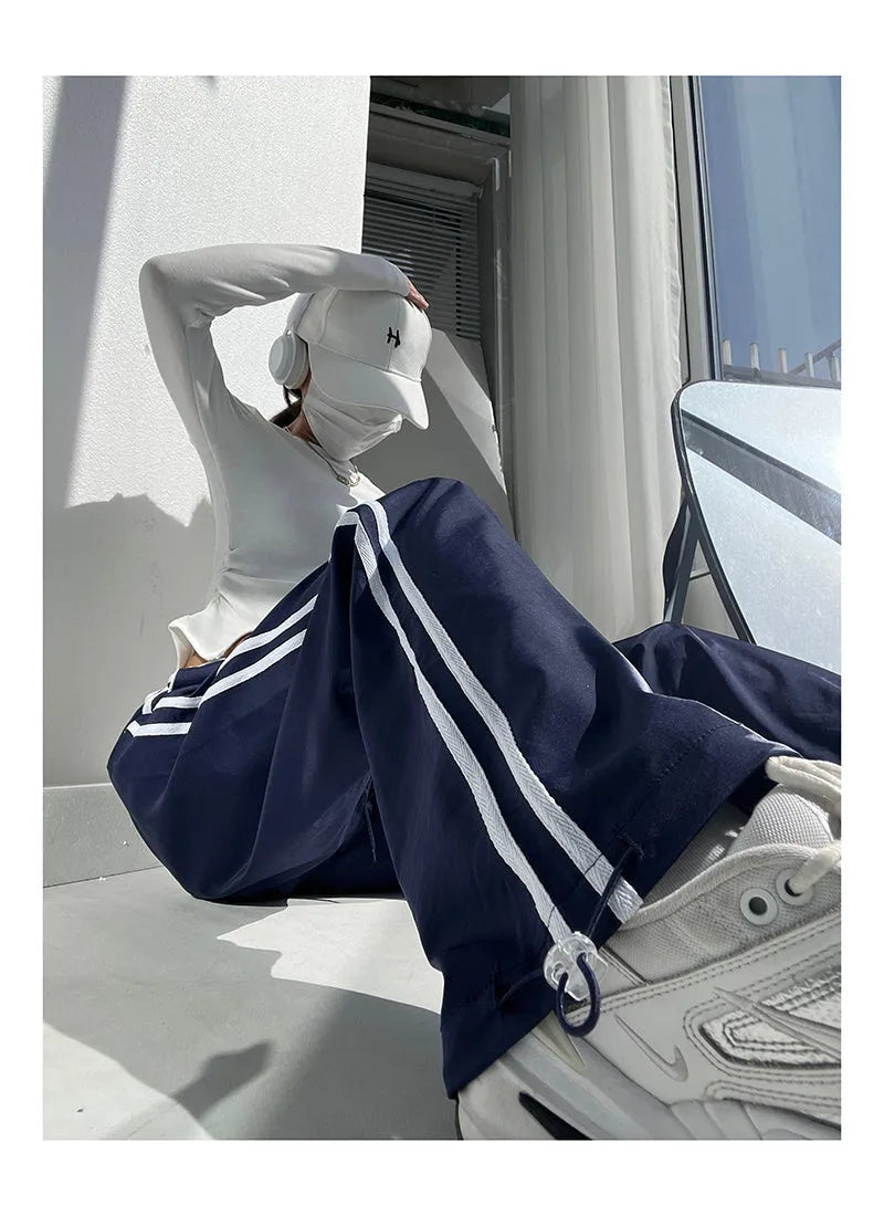 Women's loose straight-leg trousers with ribbon contrast detail in white and navy blue.