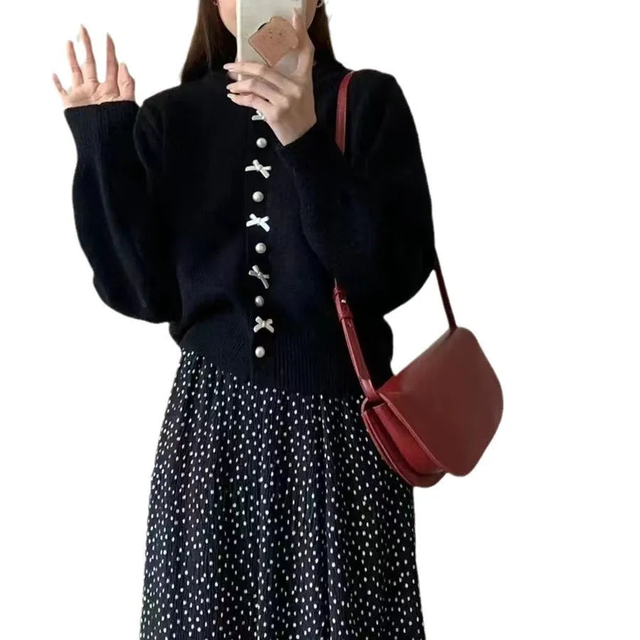Women's solid colour cardigan with a front fabric bow and pearl button fastening, shown in a light colour.