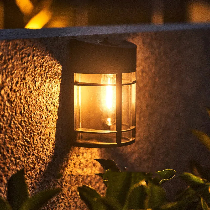 Tungsten-style solar-powered outdoor wall light with automatic light sensor mounted on a garden wall.