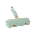 Mint green manual cat hair removal brush with detachable fur collection bin on a grey sofa