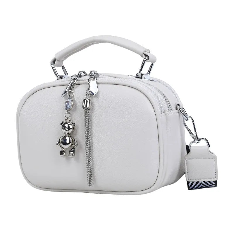 Oval-shaped women's small square bag in PU with double shoulder strap and internal phone pocket.