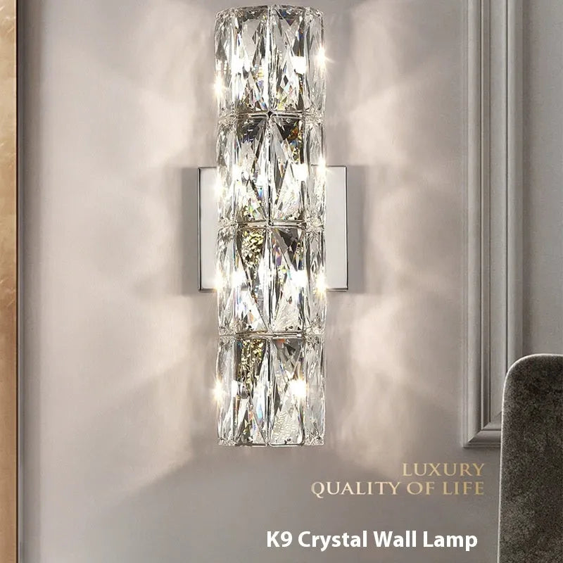 A sleek crystal wall lamp with a stainless steel base in chrome finish, mounted on a wall.