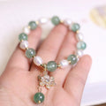 Green strawberry-shaped freshwater pearl bracelet with Chinese knot closure and small flower pendant