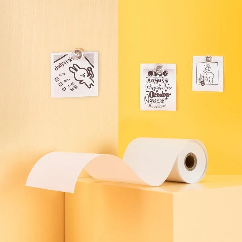 Three rolls of white 57mm thermal paper for portable printers on a blue background.