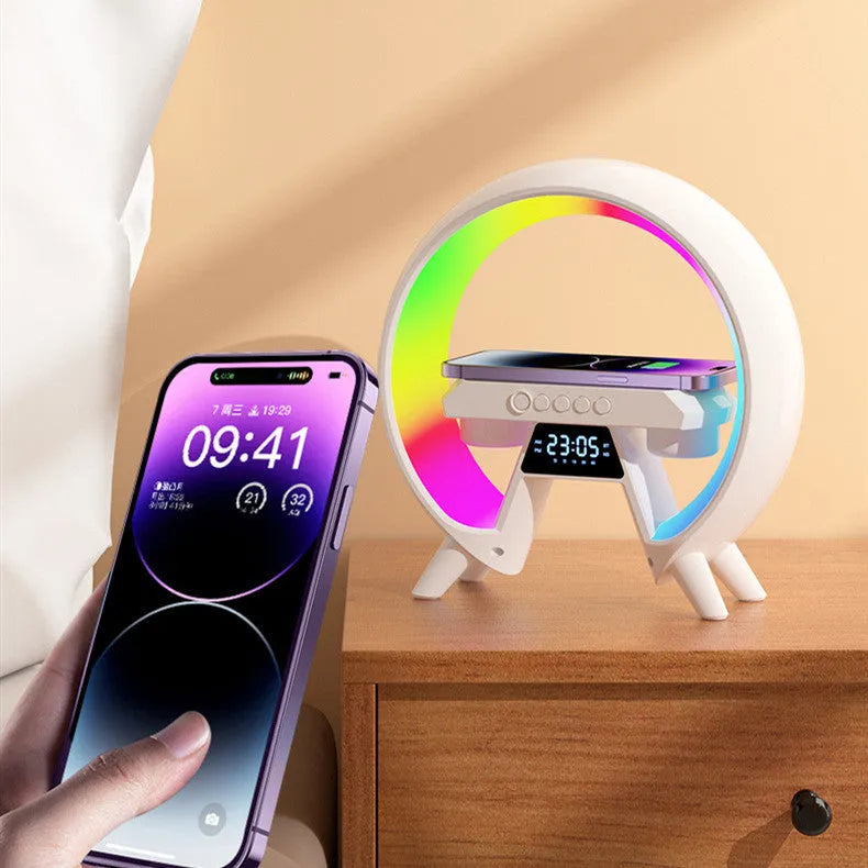 Black Bluetooth bedside speaker with wireless charging pad and LED clock display on white surface