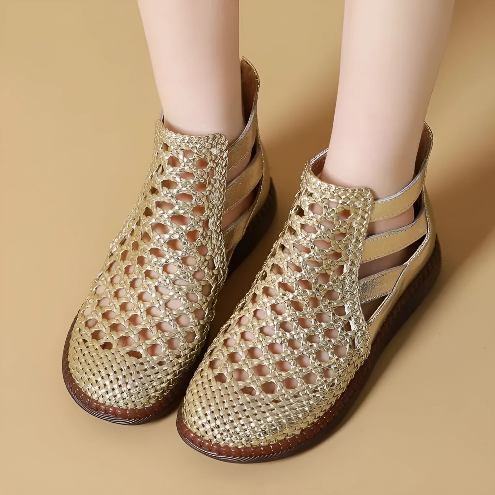 Women's flat sandals with hollow-out design in gold colour showing soft TPR soles and oversleeve style