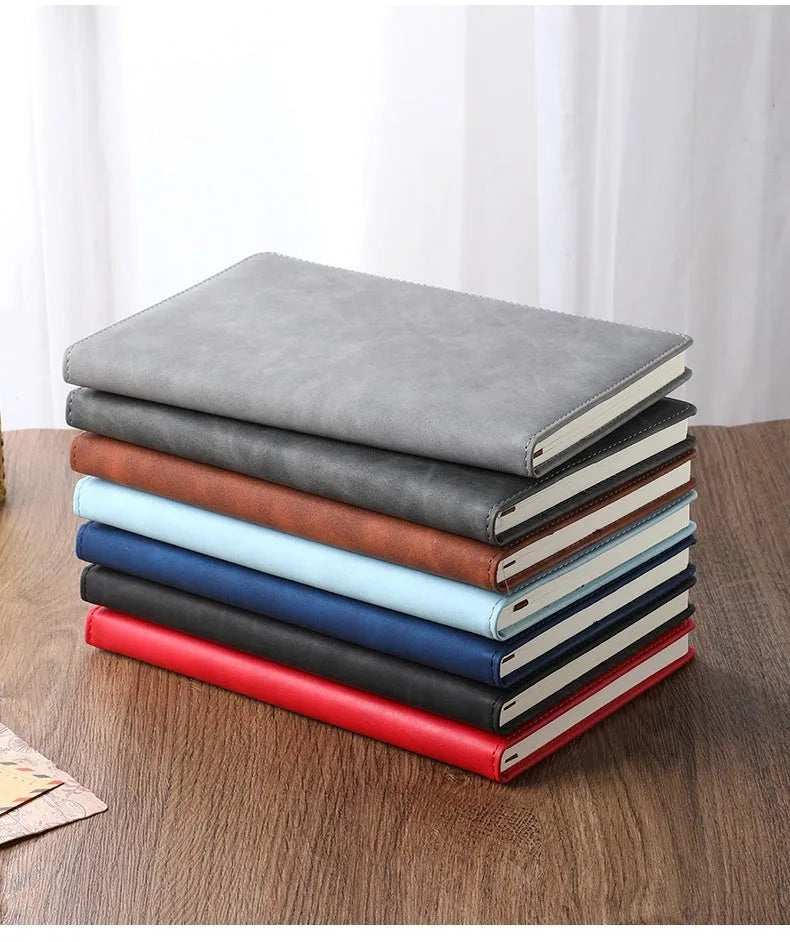 A5 notebook with imitation leather cover in various colours, open to show wood-free paper pages
