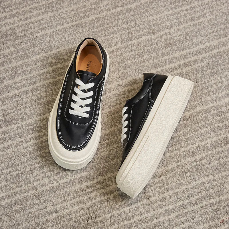 Women's black embossed cowhide leather platform sports shoes with white rubber sole and lace-up front.