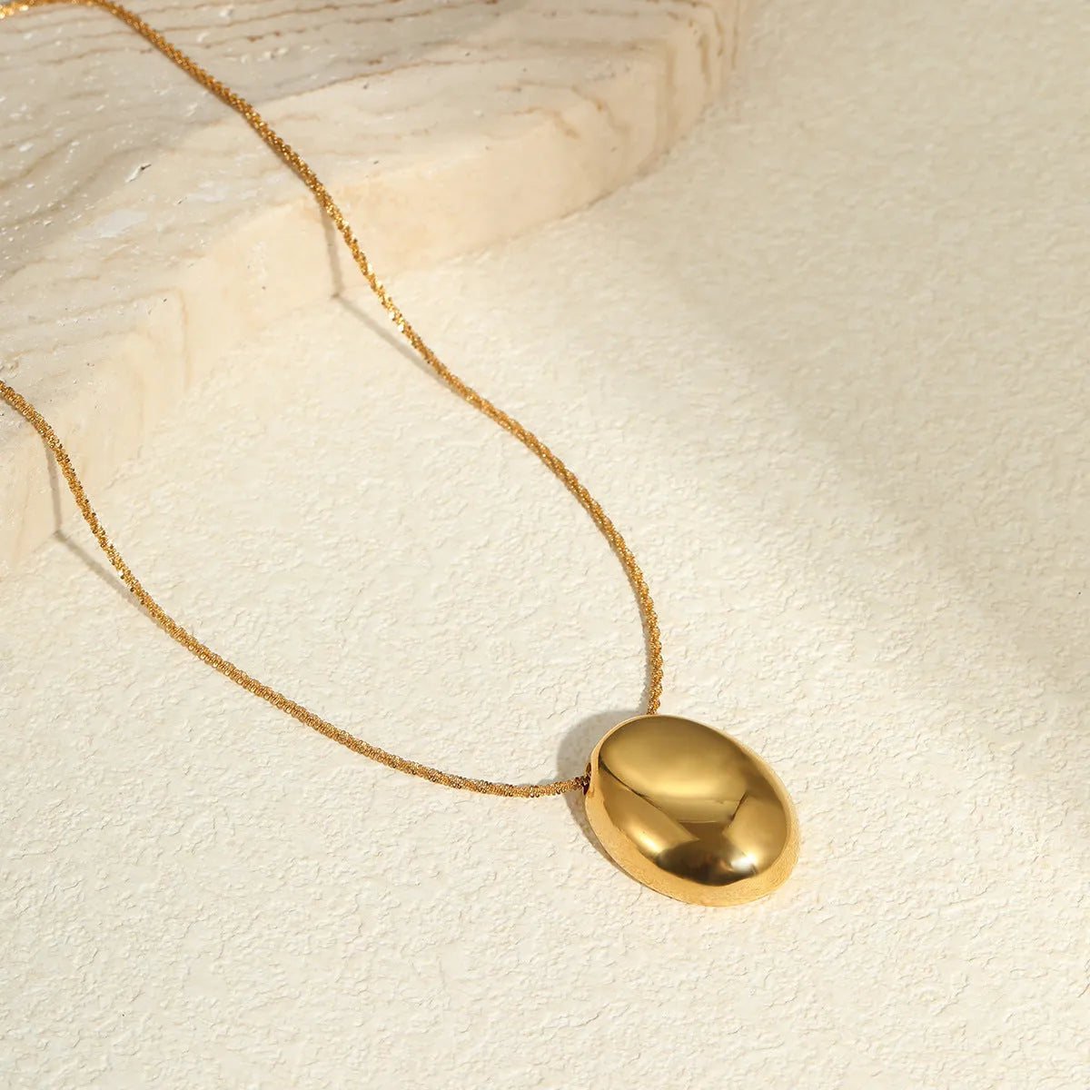 Long gold-plated necklace featuring a geometric pendant on an adjustable stainless steel chain.