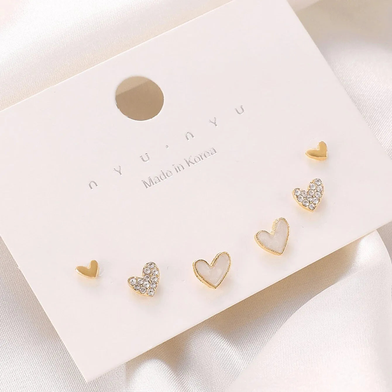 Three pairs of heart-shaped alloy earrings with electroplating in gold, black, black-white, and pink colours