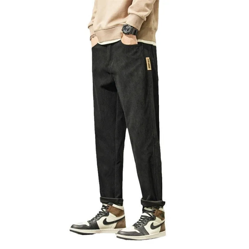 Men's tapered corduroy trousers in army green showing straight-leg street fashion style
