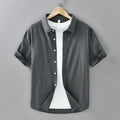 Man wearing a light grey loose-fit short-sleeved cotton cardigan-style shirt