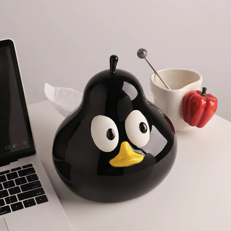 Green ceramic pear tissue box with animal style design on a wooden desktop