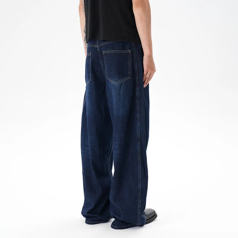 Dark blue wide leg jeans with a distressed wash and machete cut, laid flat.