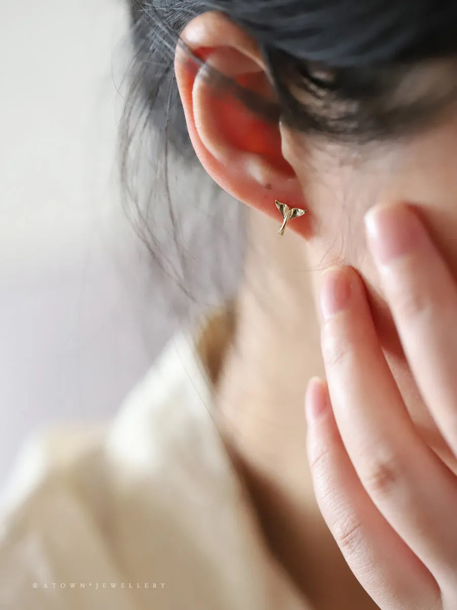 Pair of smooth fishtail earrings in gold or white gold plating, made from 925 sterling silver, showing simple design.