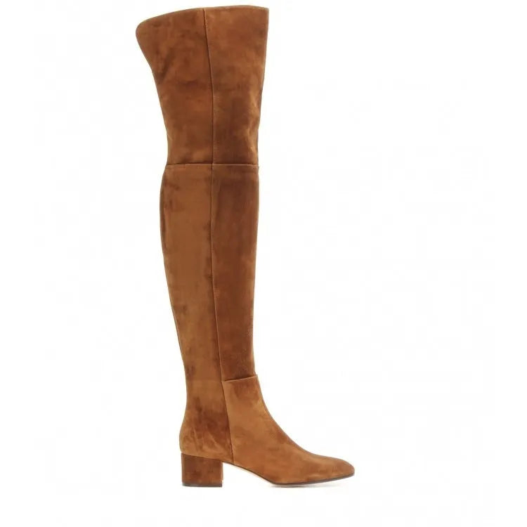 Women's grey suede over-the-knee boots with pointed toe and thick rubber sole on a wooden floor